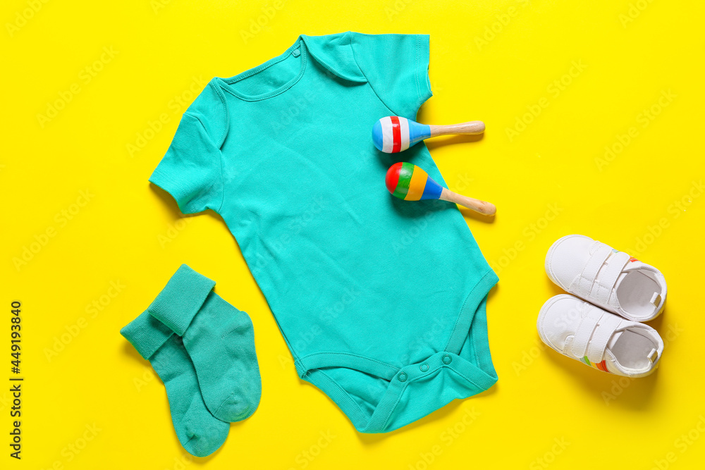 彩色背景的婴儿衣服、鞋子和玩具