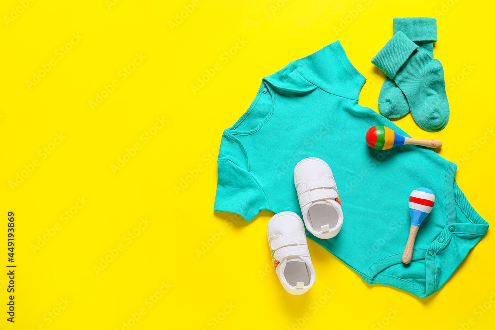 彩色背景的婴儿衣服、鞋子和玩具