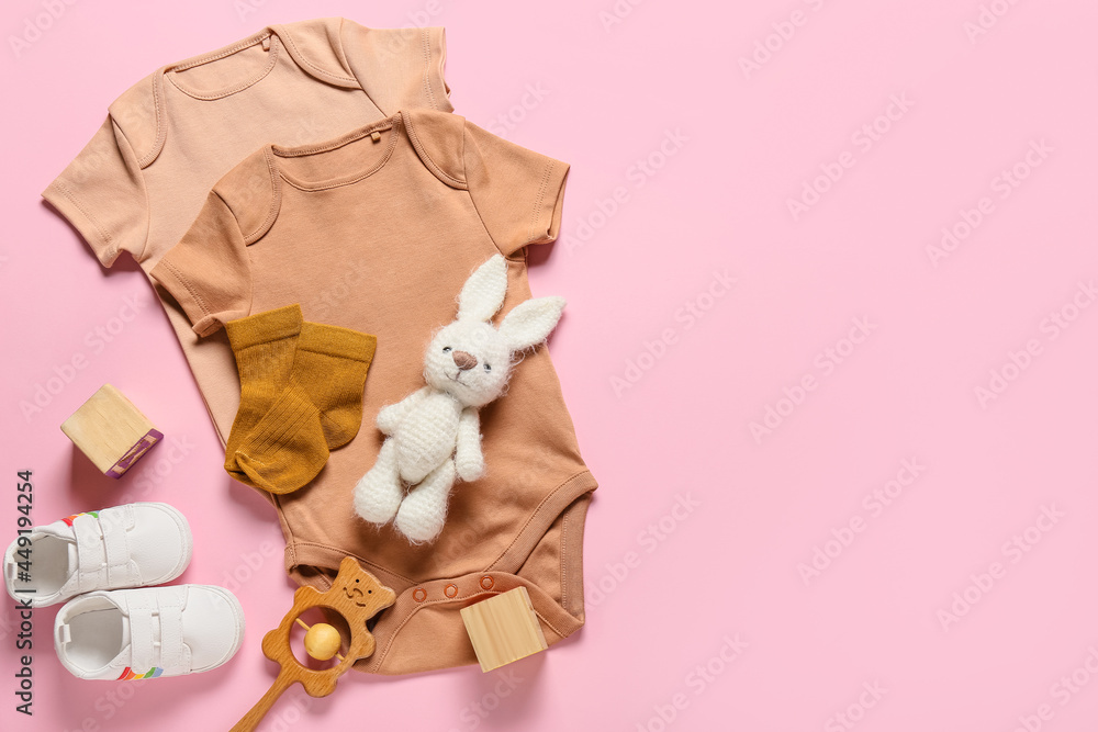 Baby clothes, shoes and toys on color background