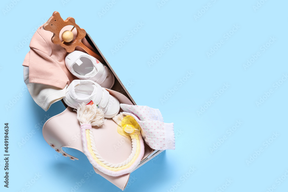 彩色背景上有婴儿衣服、鞋子、玩具和配件的盒子