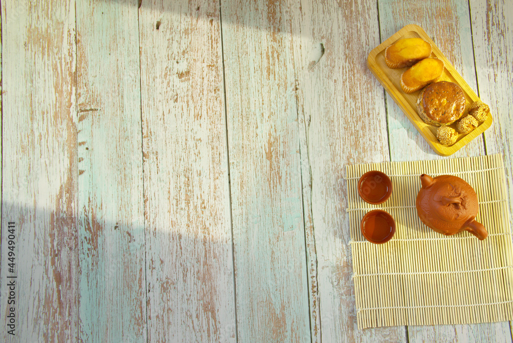 芝麻糕点，木质纹理桌子上的一壶茶，美味的早餐，复制空间
