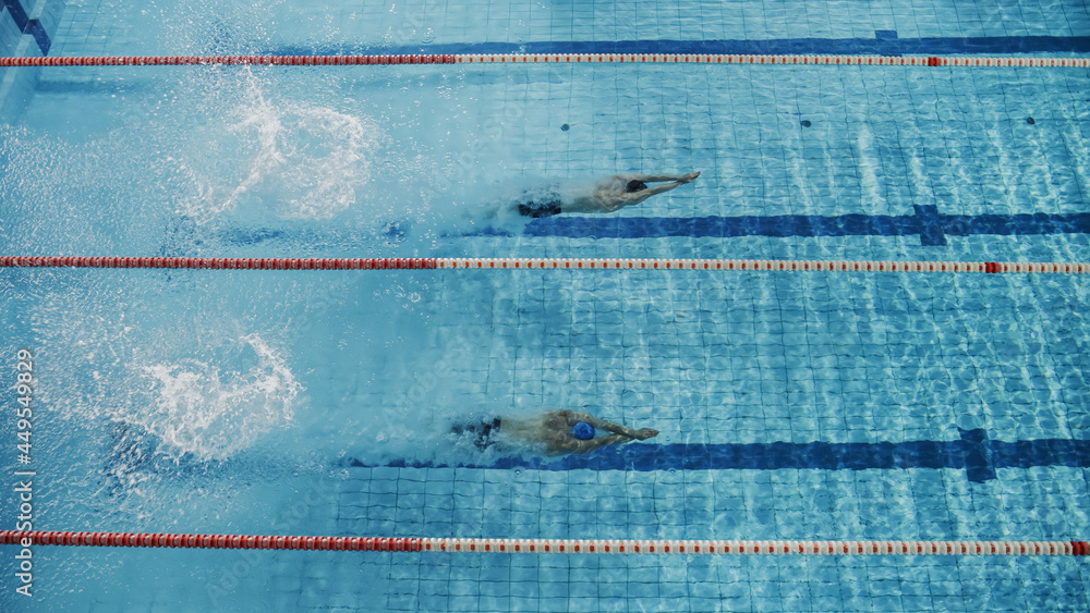 游泳比赛：两名职业游泳运动员在游泳池跳水，在水下游泳。运动员比赛