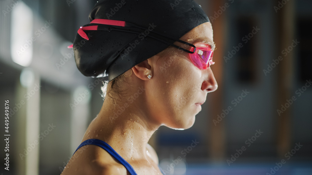 游泳池里美丽的职业女游泳运动员，戴着帽子，戴着护目镜，看起来很自信啊