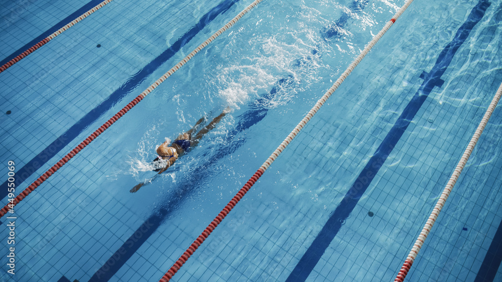 游泳池里美丽的女游泳运动员。专业运动员优雅地全速游泳。女人