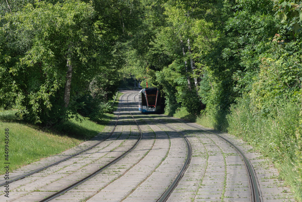 轨道上的城市或郊区有轨电车在远处模糊。混凝土板上的无尽弯曲铁路