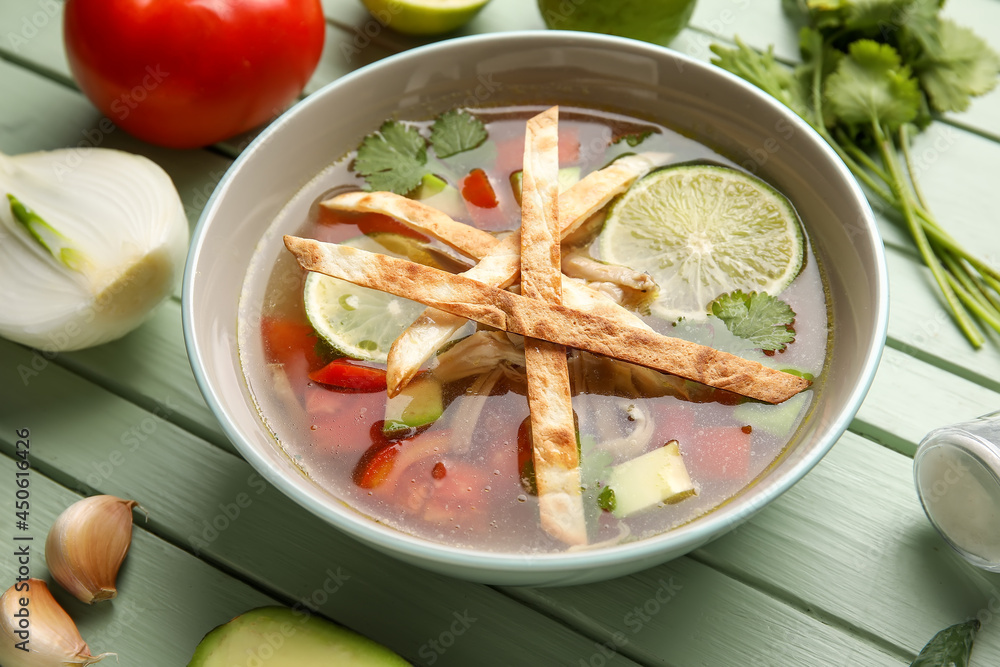 一碗美味的Sopa de Lima汤，彩色木质背景