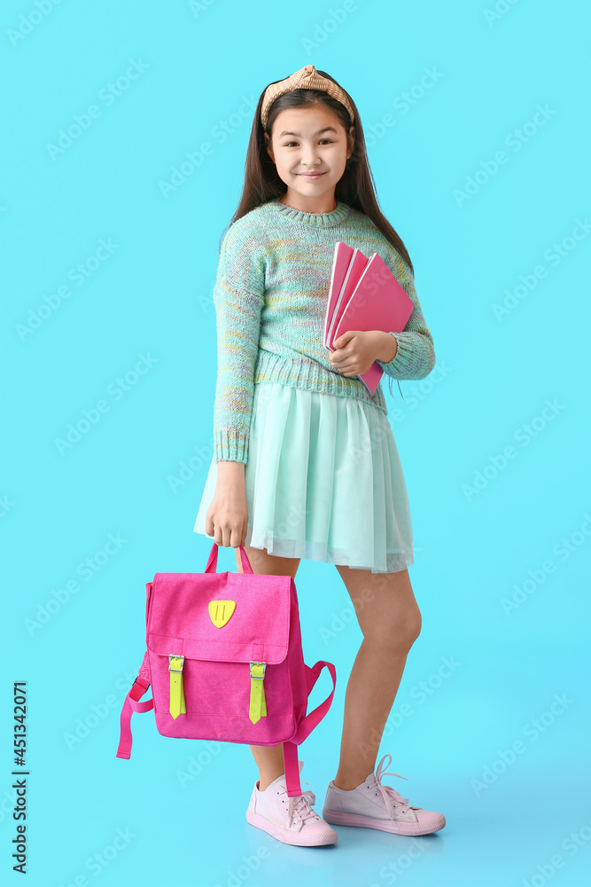 可爱的小女孩，彩色背景时尚的学校背包
