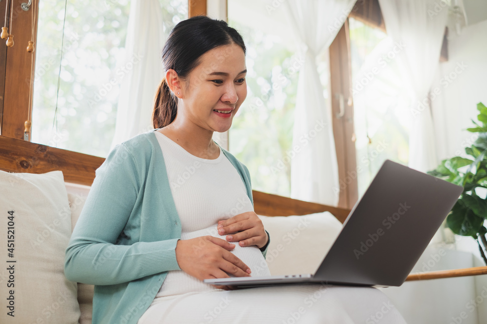 亚洲孕妇在家使用笔记本电脑