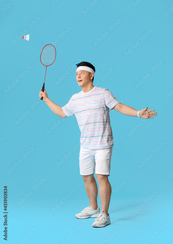 Sporty male badminton player on color background