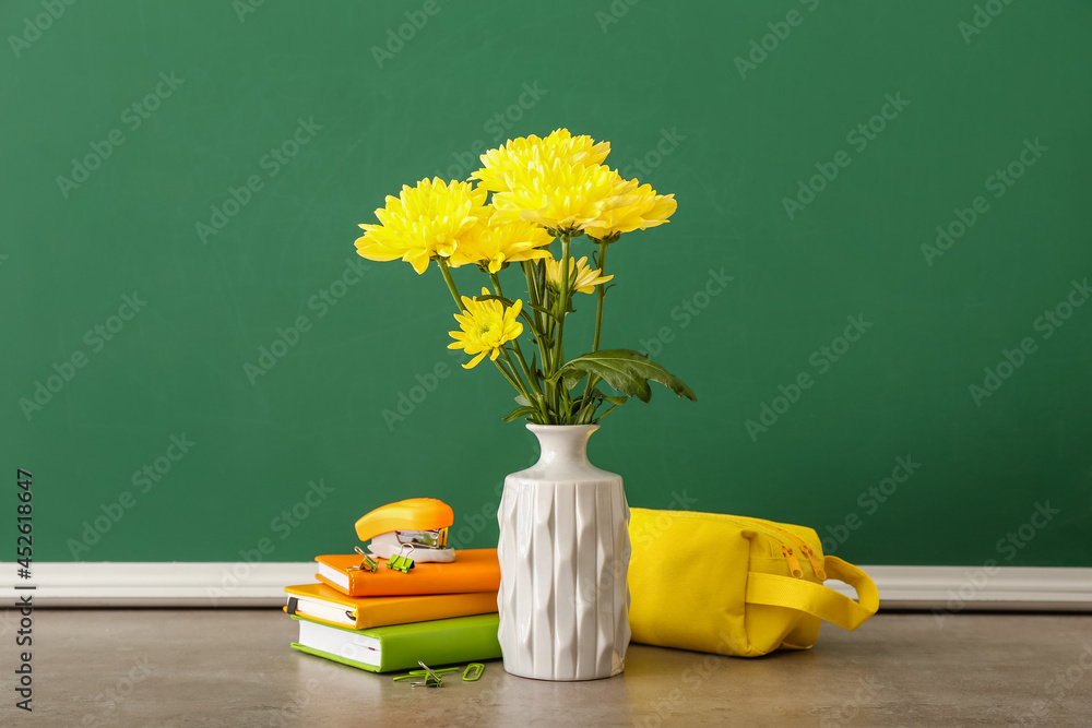 教室桌子上放着鲜花和文具的花瓶。教师节庆祝活动