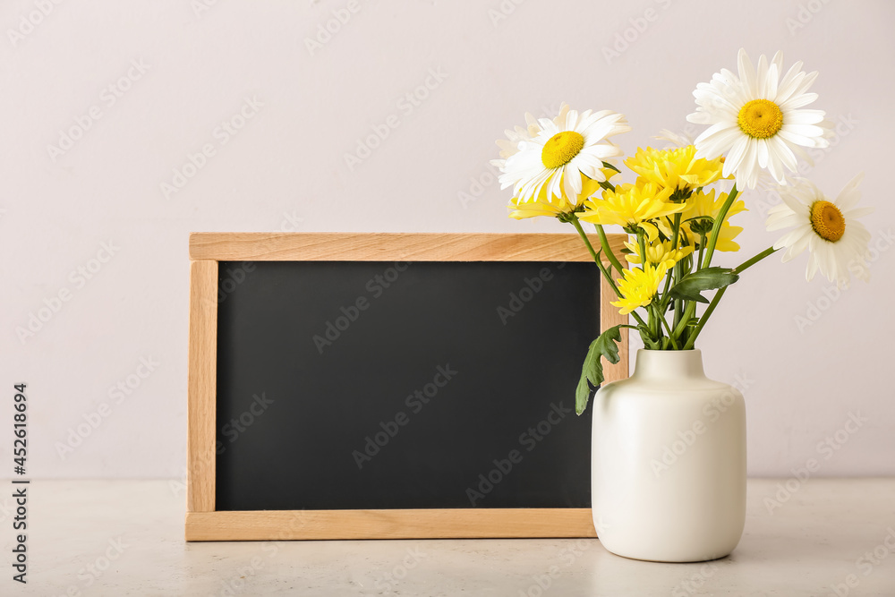 浅背景花瓶，花瓶上有鲜花和黑板。教师节庆祝活动
