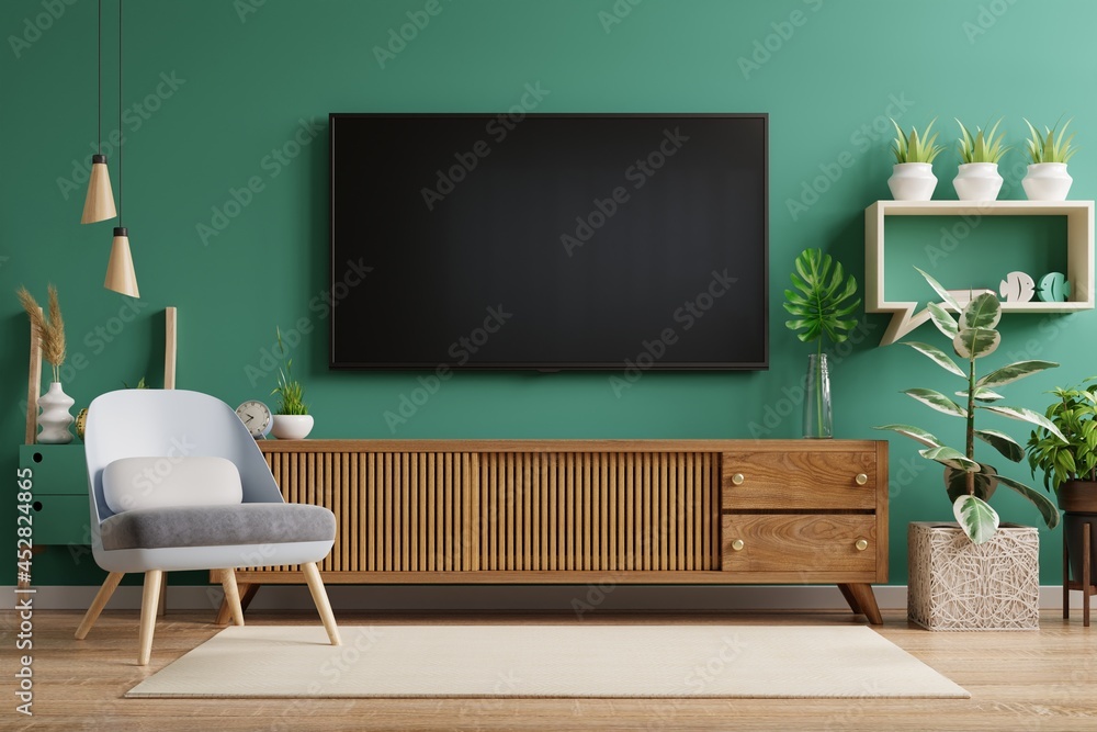 客厅内部有电视柜和带绿色墙壁的皮扶手椅。