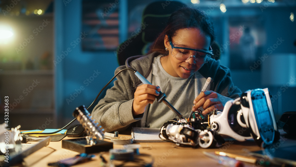 年轻的青少年多民族女学生正在学习电子产品、焊丝和电路板