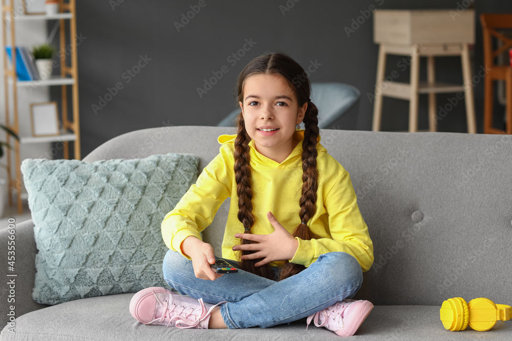 Cute girl watching cartoons at home