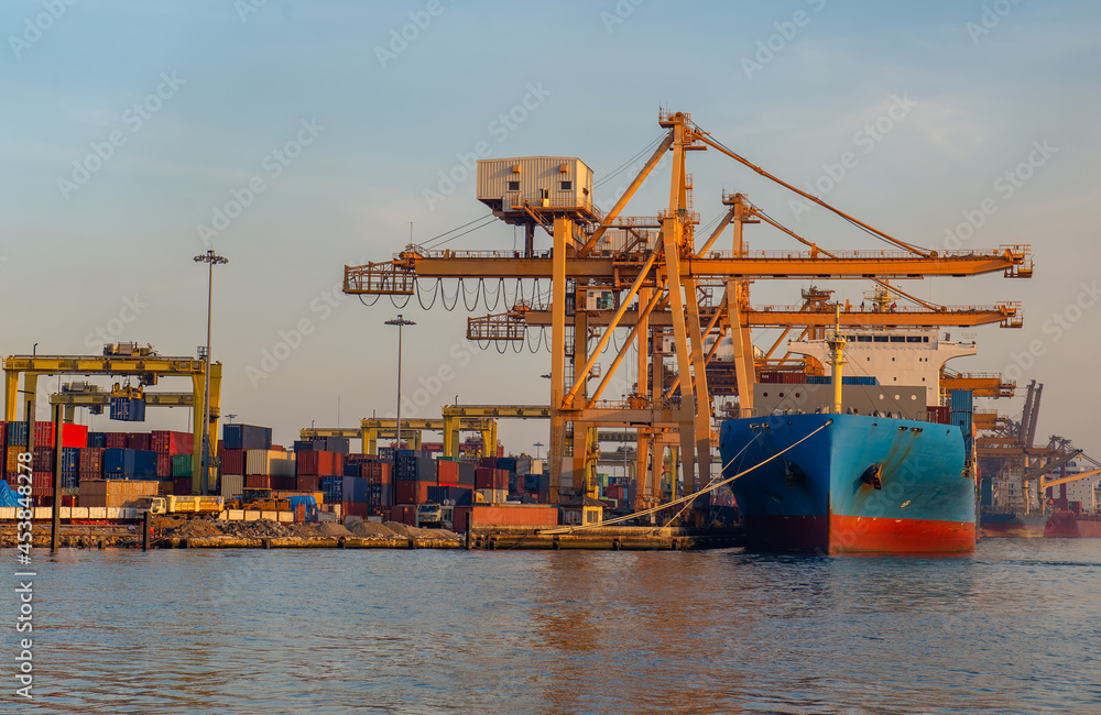 进出口业务和物流中的集装箱船。用起重机将货物运到港口。水