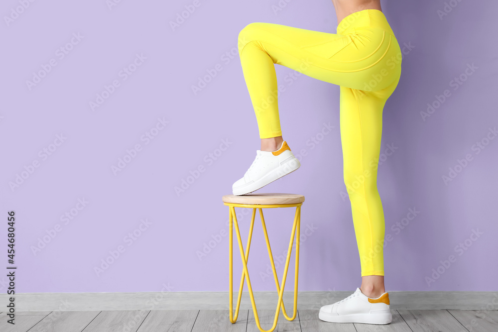 运动型年轻女性，椅子靠近彩色墙
