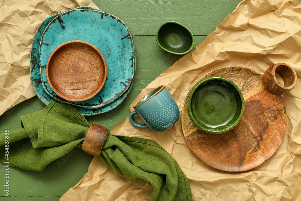 彩色木质背景上的不同餐具和餐巾纸