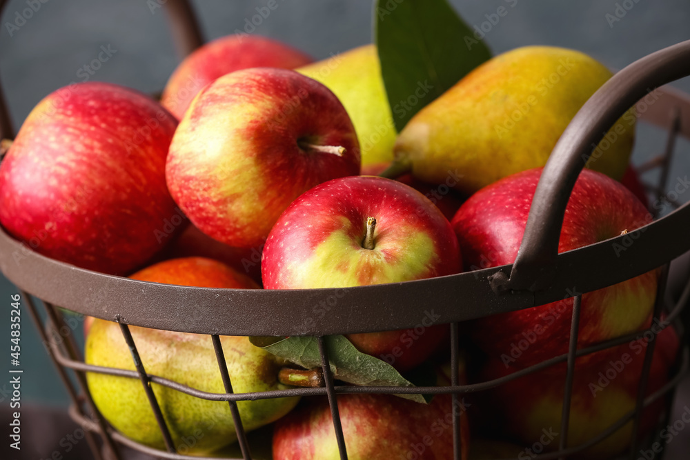 篮子里有成熟的梨和苹果，背景为深色，特写