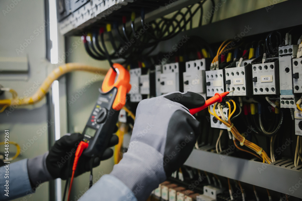 电气工程师测试保护继电器上的电气装置和接线，并测量它们w