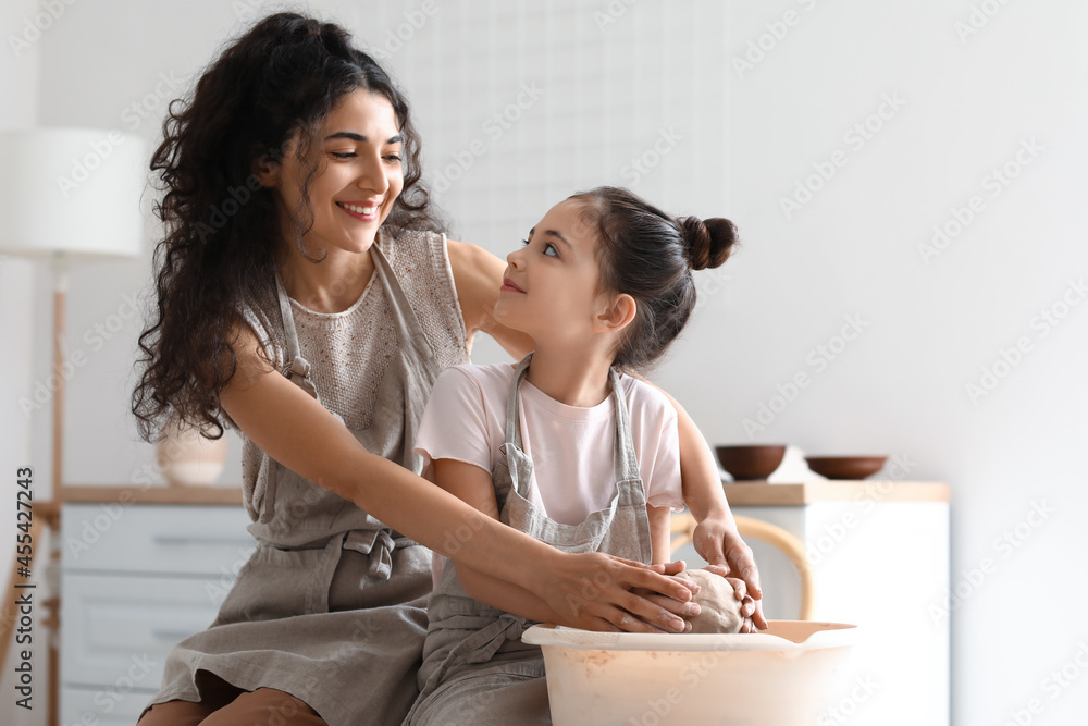 小女孩和妈妈在家做陶瓷壶