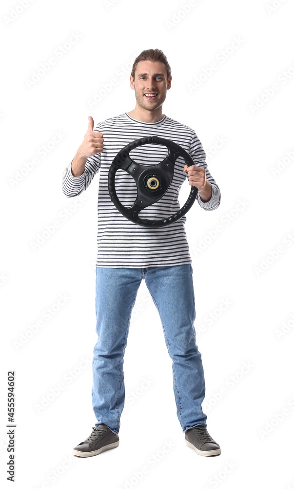 Young man with steering wheel showing thumb-up on white background