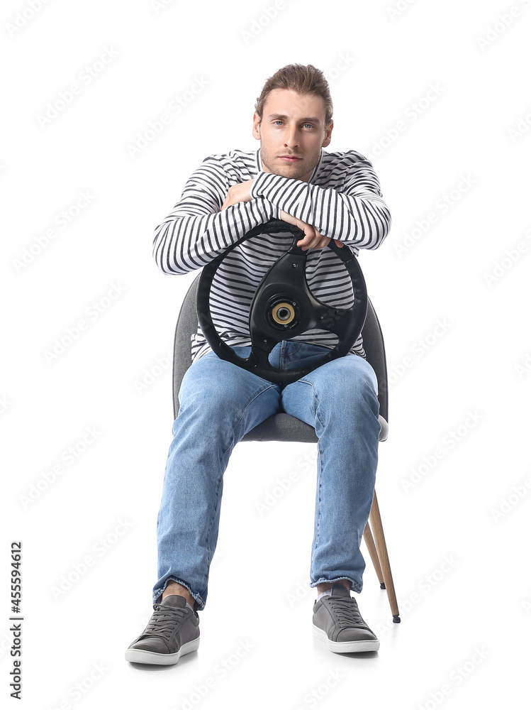 白人背景下坐在椅子上的年轻人，带着方向盘