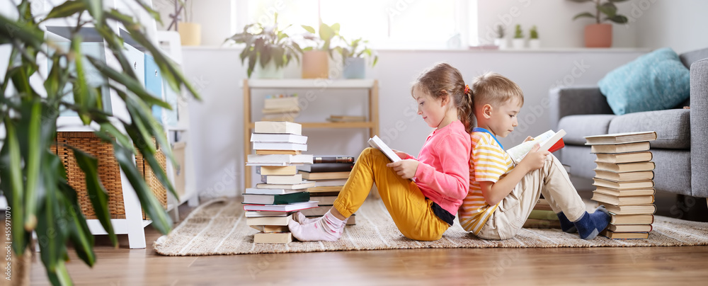 两个孩子坐在房间的地板上看书