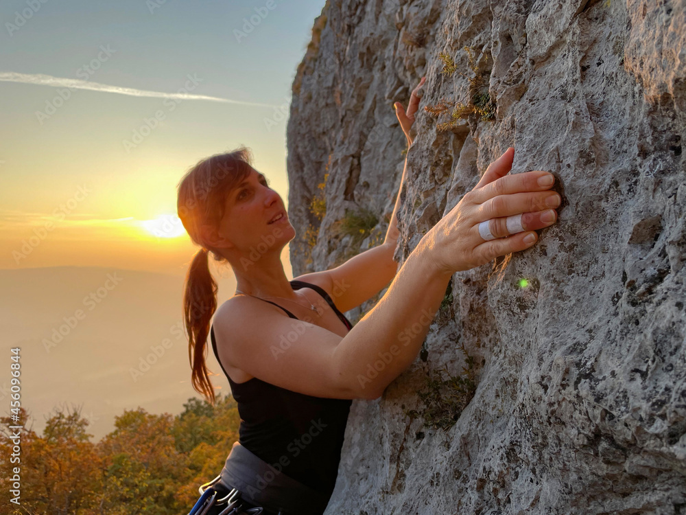 特写：快乐的女登山者在阳光明媚的Crni Kal攀登充满挑战的悬崖。