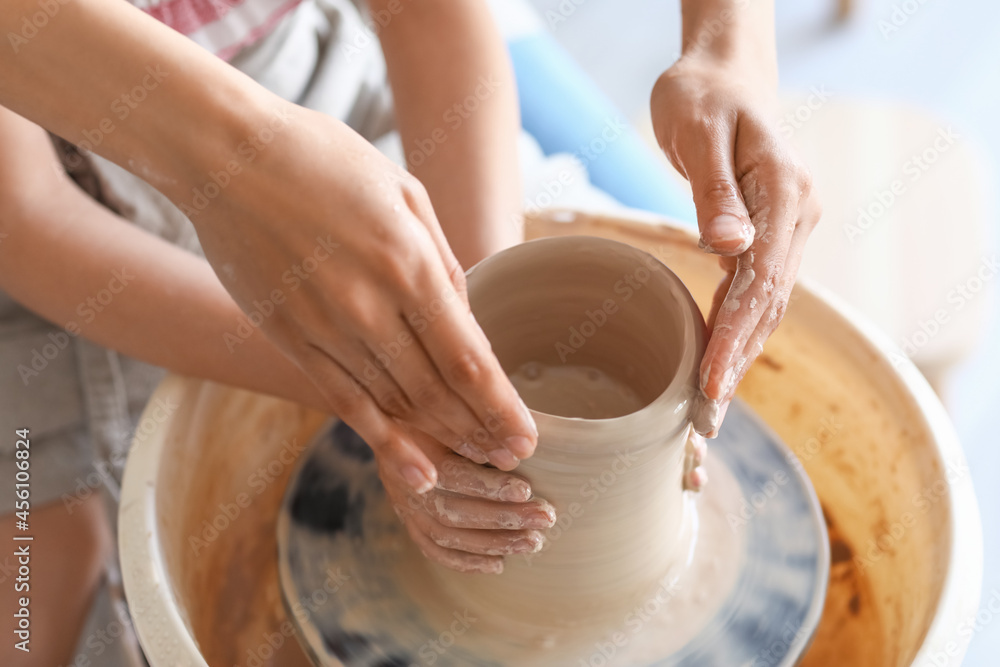 小女孩和妈妈在家做陶瓷壶，特写