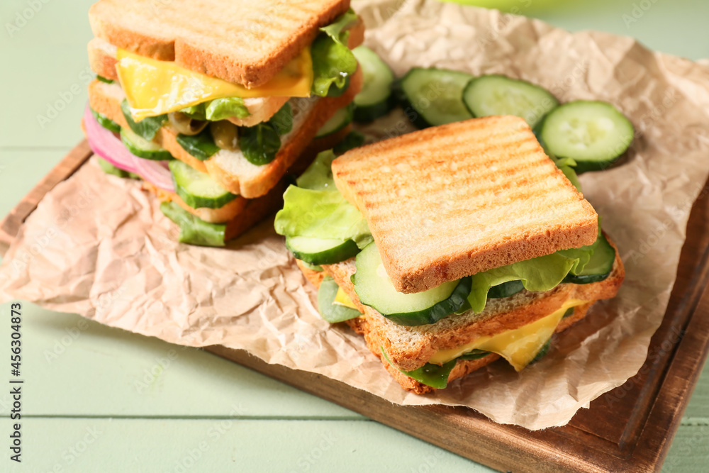彩色木质背景上的美味三明治，特写