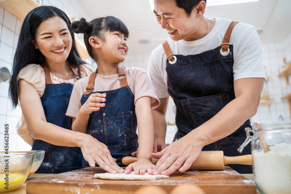 亚洲幸福家庭待在家里的厨房里，和孩子一起烤面包和食物