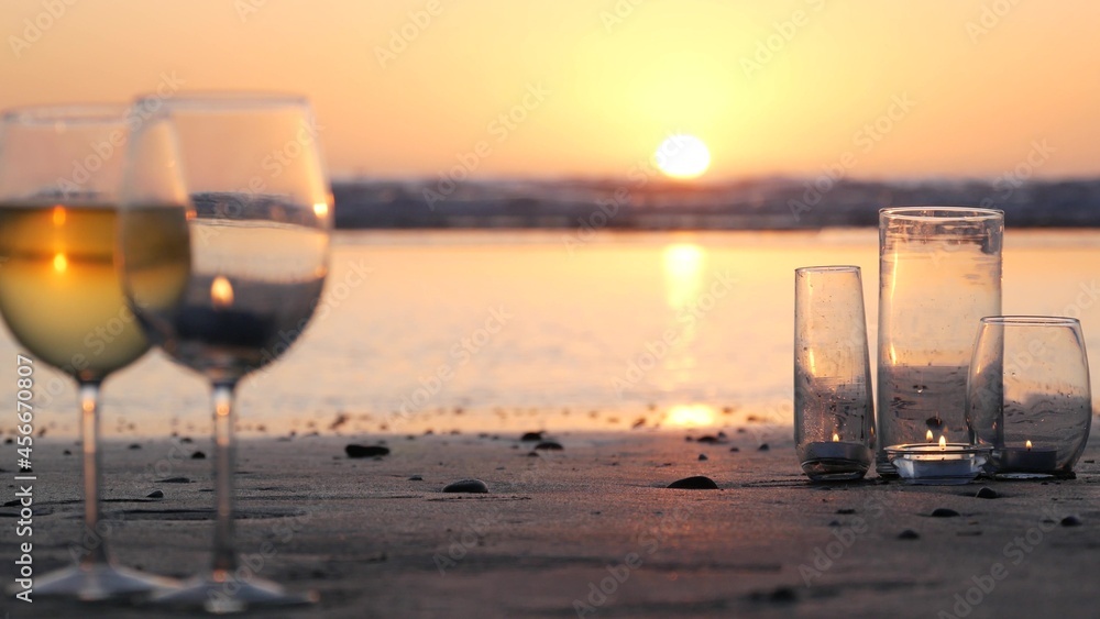 玻璃中的蜡烛火焰灯，加州海浪旁的浪漫海滩约会，夏天的海水。Candl