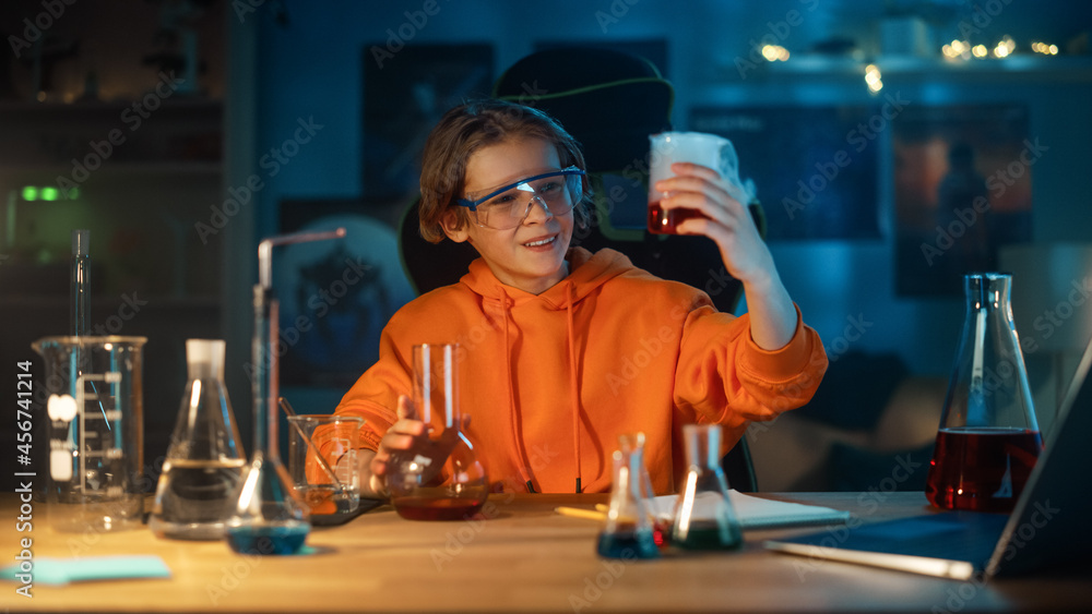 Smart Young Boy in Safety Goggles Mixes Colorful Chemicals in Beakers at Home. Teenager Conducting E