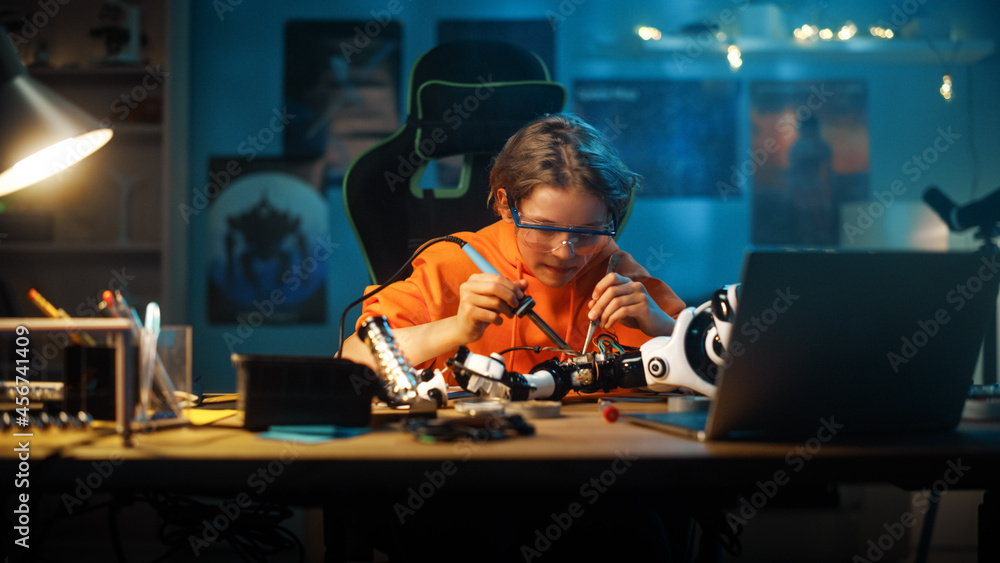 聪明的青少年男孩正在学习电子产品、焊丝和电路板