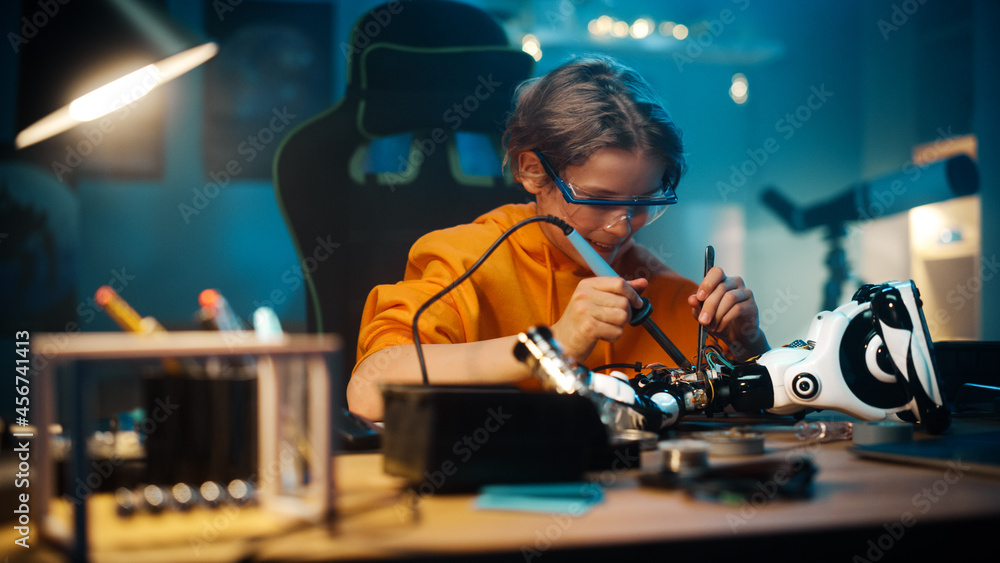 聪明的青少年男孩正在学习电子产品、焊丝和电路板