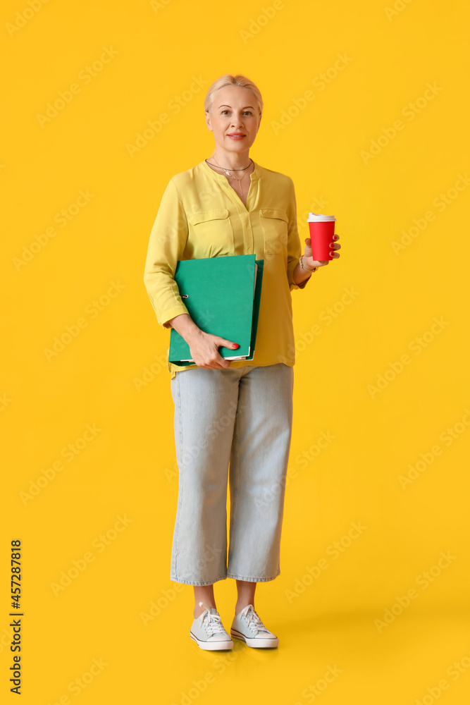 彩色背景上有文件夹和咖啡的成熟女性肖像