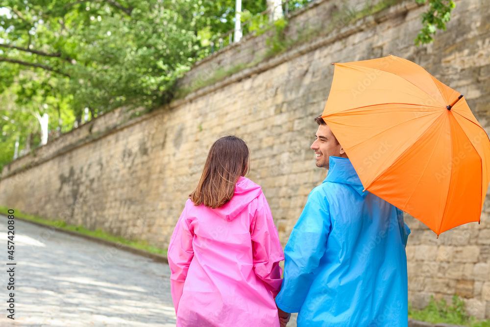 带伞的年轻情侣在户外散步