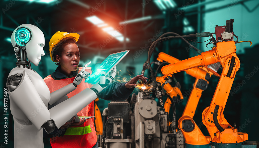 机械化工业机器人和人类工人在未来工厂合作。人工概念