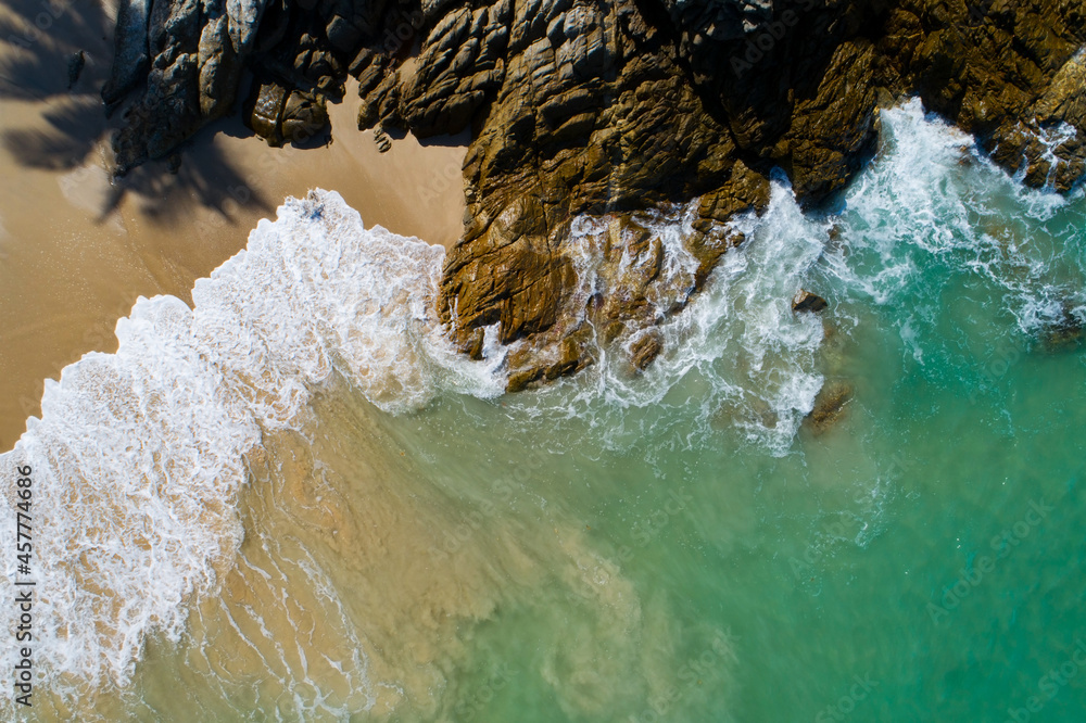 鸟瞰图自上而下的海岸波浪拍打在岩石上石头海岸美丽的绿松石海面