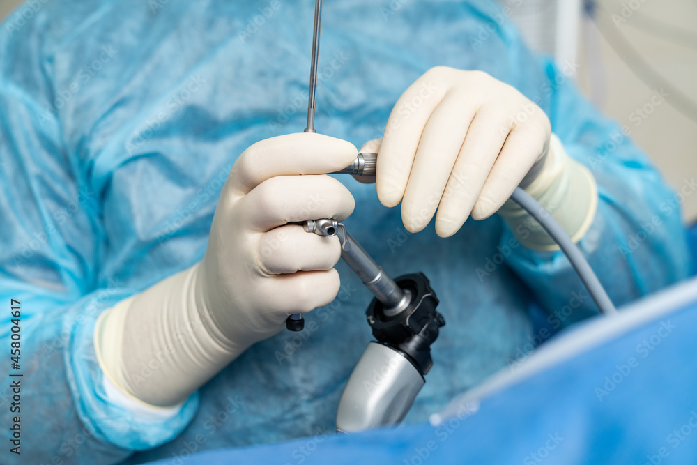 专业医疗专家使用仪器。身穿蓝色制服的外科医生使用设备