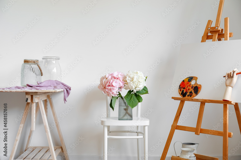 靠近灯光墙的椅子上放着绣球花的花瓶