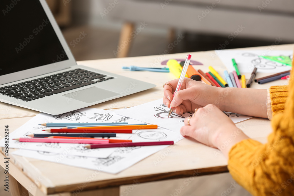 Young female calligraphist working in office