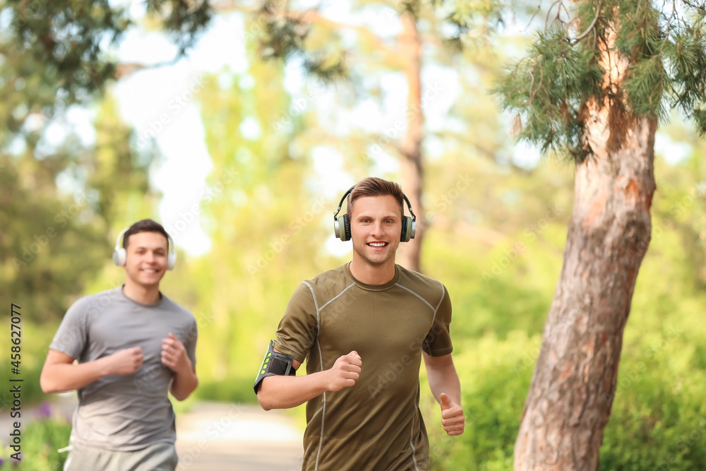 Sporty young man with headphones running in park