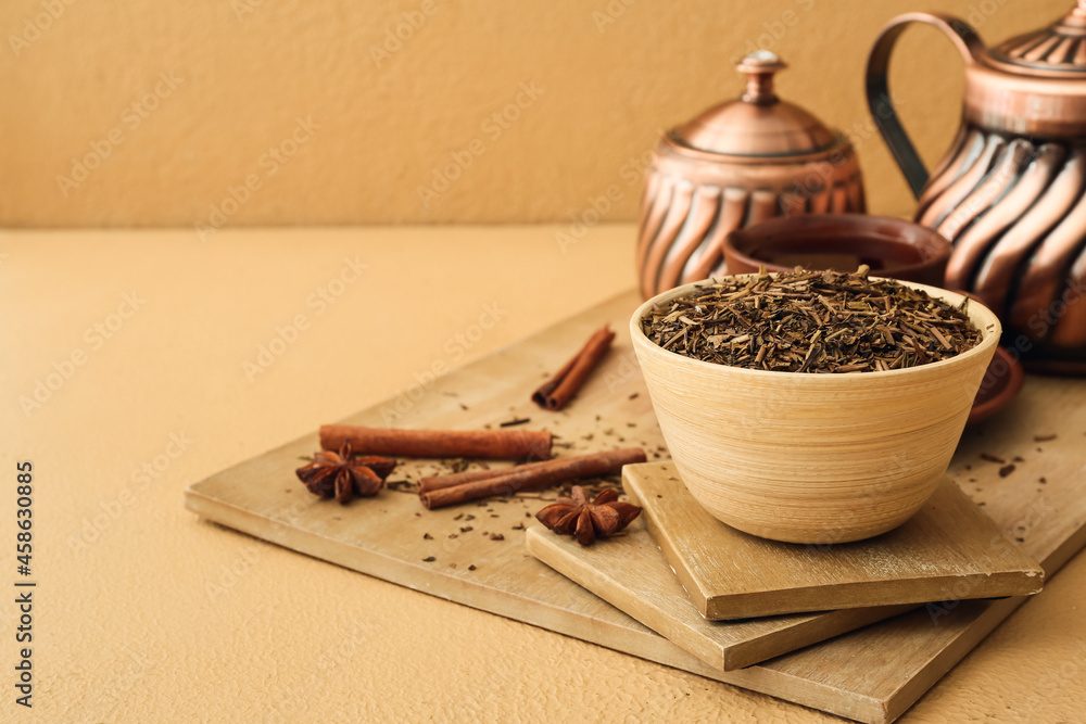 彩色背景上有干可可茶绿茶、茶壶和一杯热饮的木板
