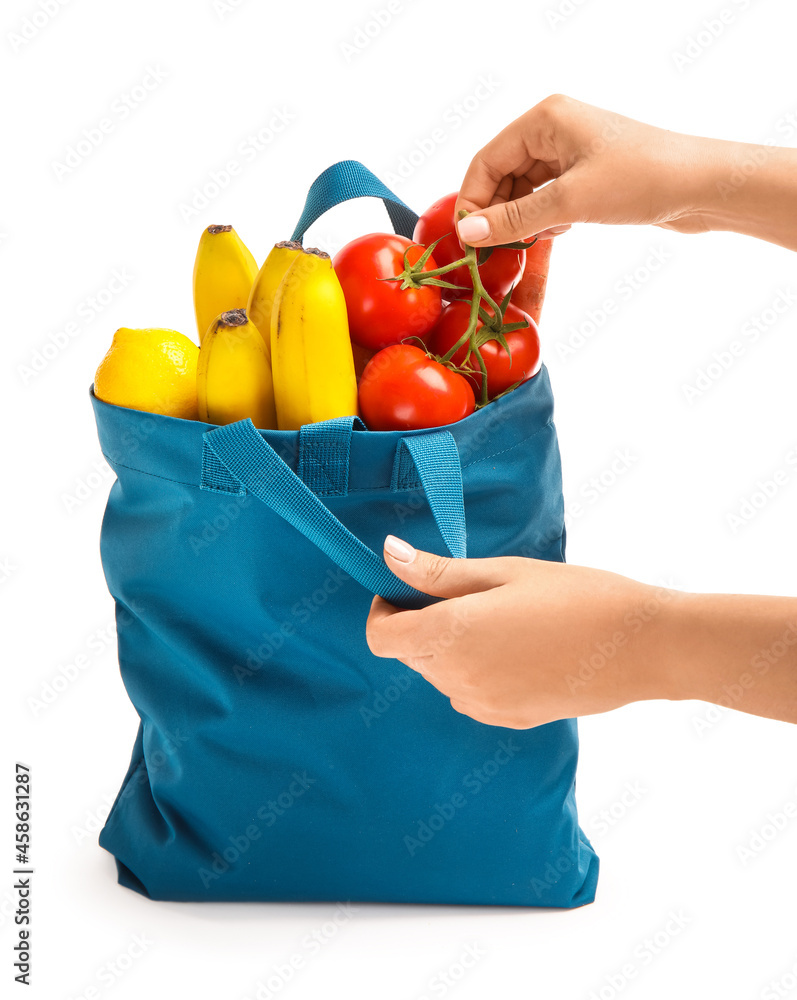 拿着白色背景水果和蔬菜的环保袋的女人
