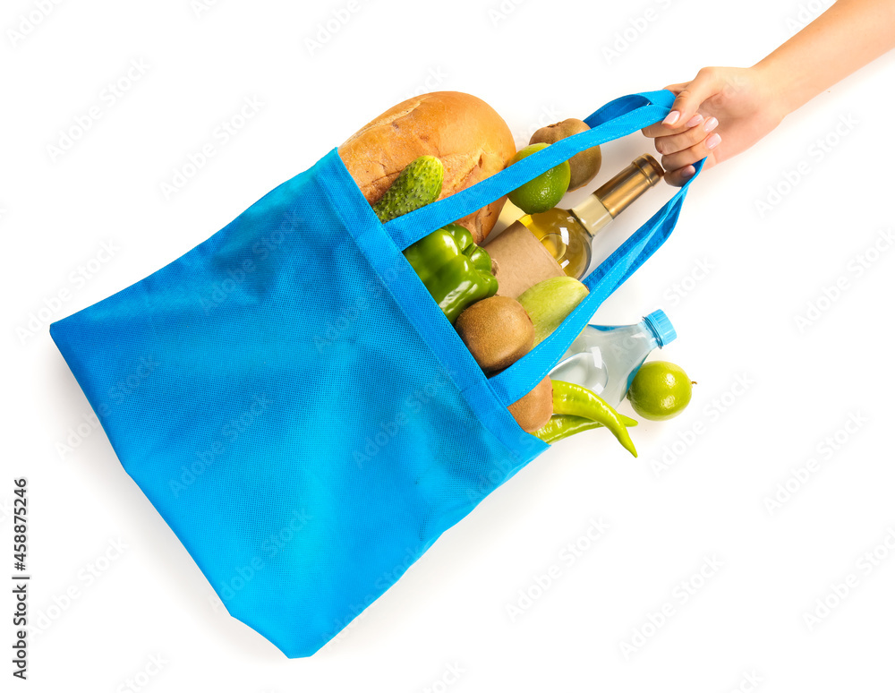 女人拿着环保袋，里面装着白色背景的产品、一瓶葡萄酒和水