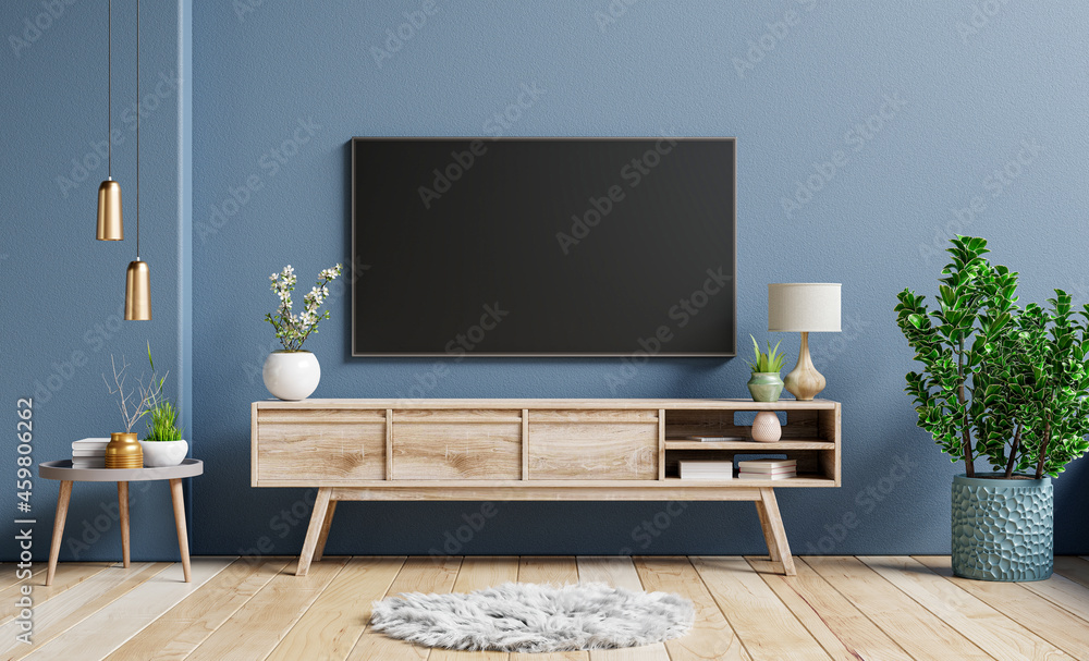 Mockup television on cabinet in contemporary empty room with dark blue wall behind it.