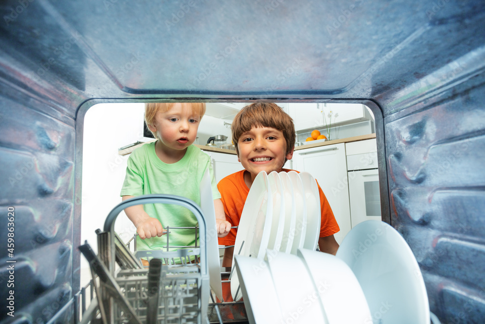 两个男孩从洗碗机里卸下盘子