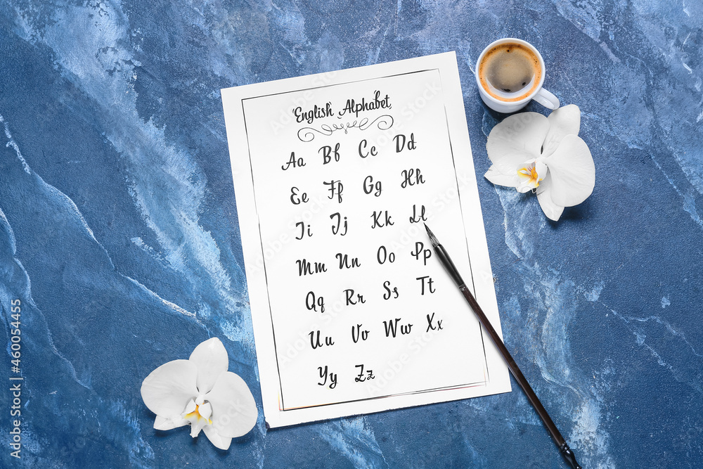 Paper with alphabet, brush, flowers and cup of coffee on blue background
