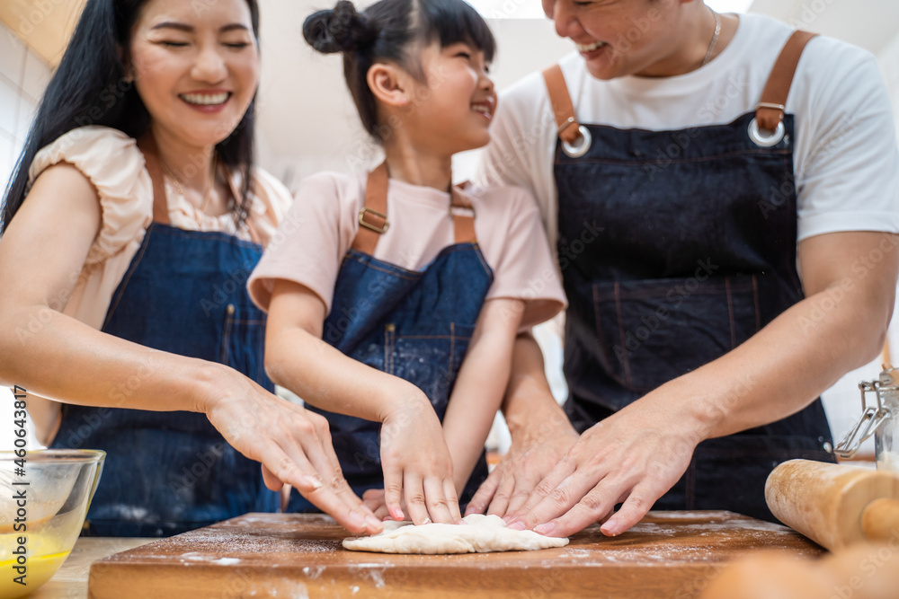 亚洲幸福家庭待在家里的厨房里，和孩子一起烤面包和食物。